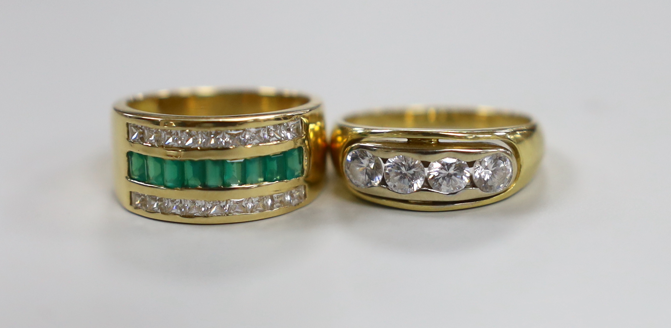 A modern 750 yellow metal and four stone simulated diamond set half hoop ring and a similar simulated emerald and simulated diamond set three row half hoop ring, gross weight 12.7 grams.